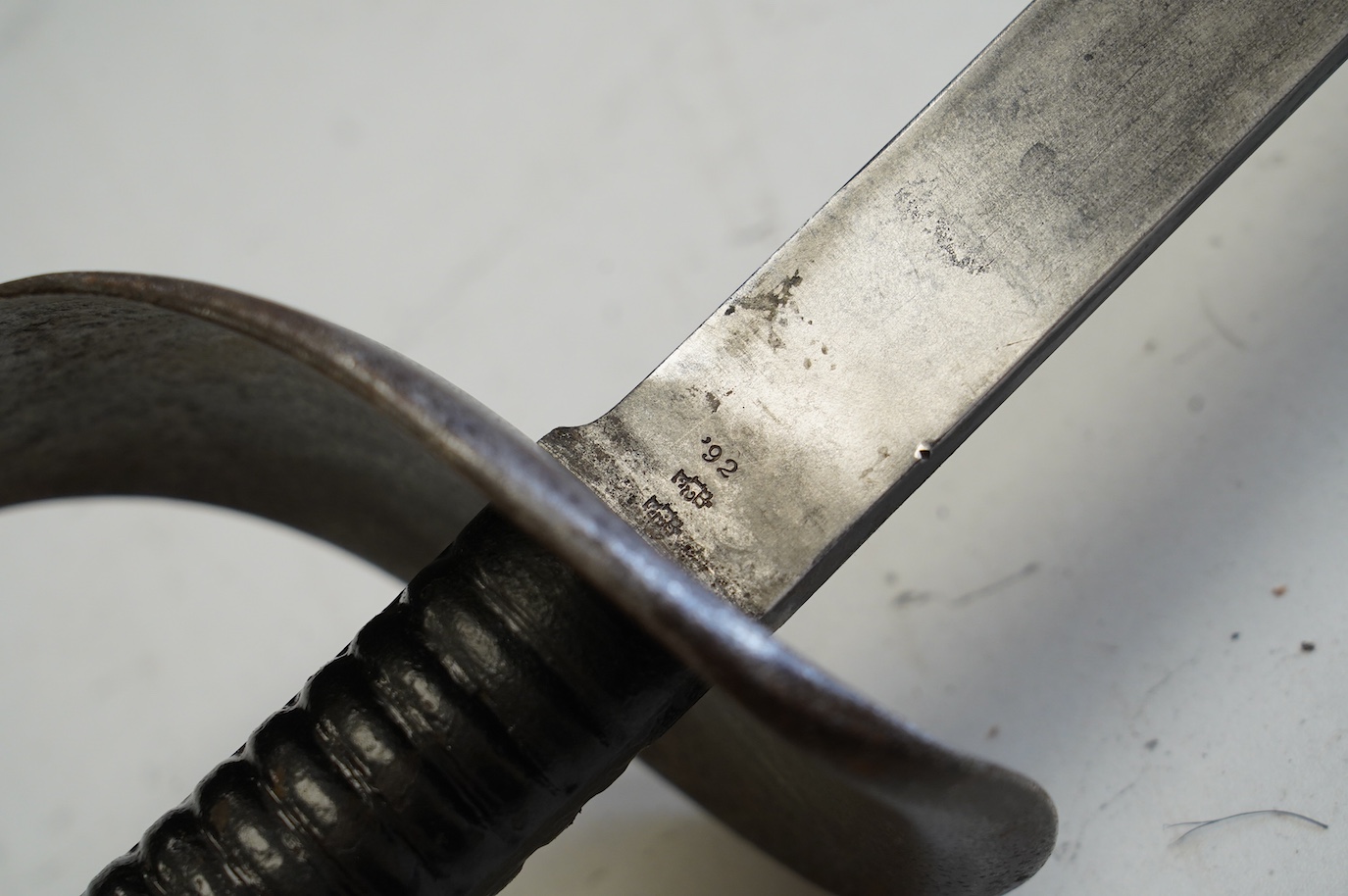 A naval boarding cutlass, blade with issue stamps, 1892, iron guard (pitted) and ribbed iron grips, blade 70.5cm. Condition - worn